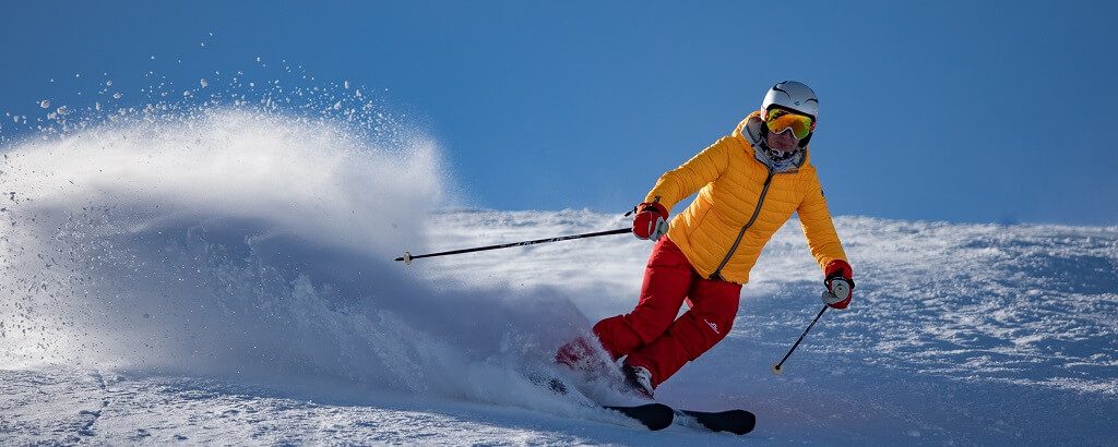 skiier in red and yellow in the winter olympics