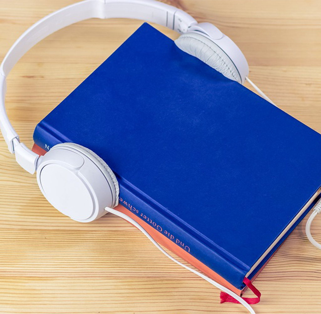 headphones on a book, representing the best audible books