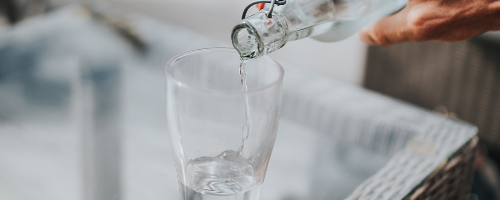 water poured into a glass to avoid dehydration